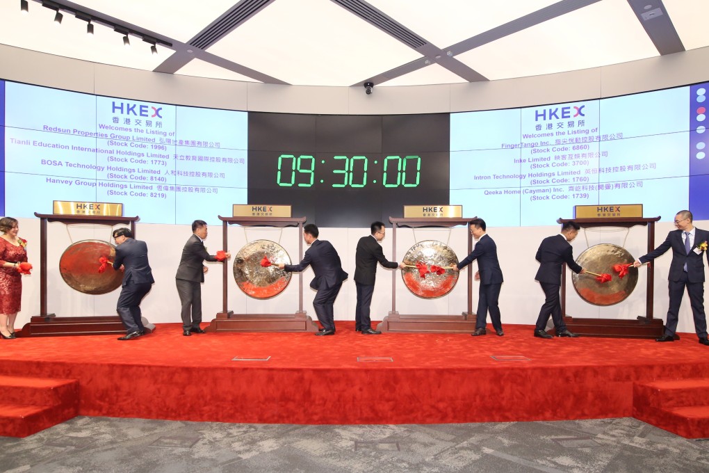 Executives of eight companies struck the ceremonial gong at the Hong Kong stock exchange on July 12, 2018 to mark the debut of their companies’ stocks on the bourse. The center stage at the exchange was not large enough to accommodate a gong for each executive. Photo: SCMP/Handout