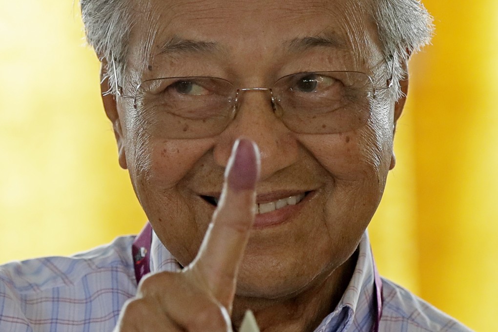 Malaysian Prime Minister Mahathir Mohamad shows his finger marked in ink after voting in May’s general election. Photo: AP