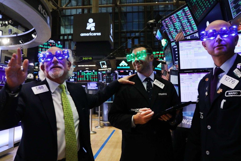 Traders wear 2019 novelty glasses as they work on the floor of the New York Stock Exchange on the last day of the trading year in New York City. Photo: Agence France-Presse