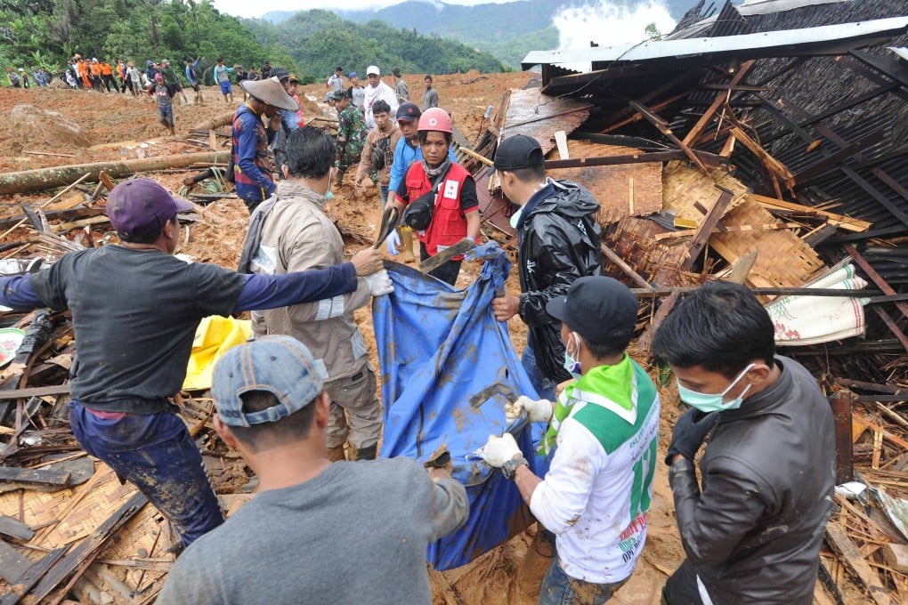 Indonesian rescuers carry the remains of a landslide victim at Sirnaresmi village in Sukabumi, Indonesia on January 1. Photo: EPA