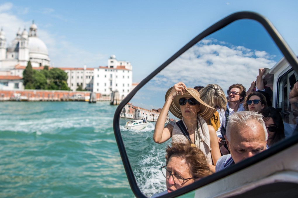 Tourists ride on a vaporetto in Venice. Italy's newly-approved budget includes the introduction of an entrance tax for tourists who visit Venice. Photo: EPA