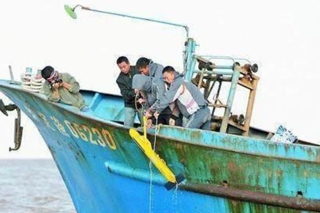 Chinese fishermen haul a ‘suspicious underwater device’ on to their boat earlier this year. Photo: Handout