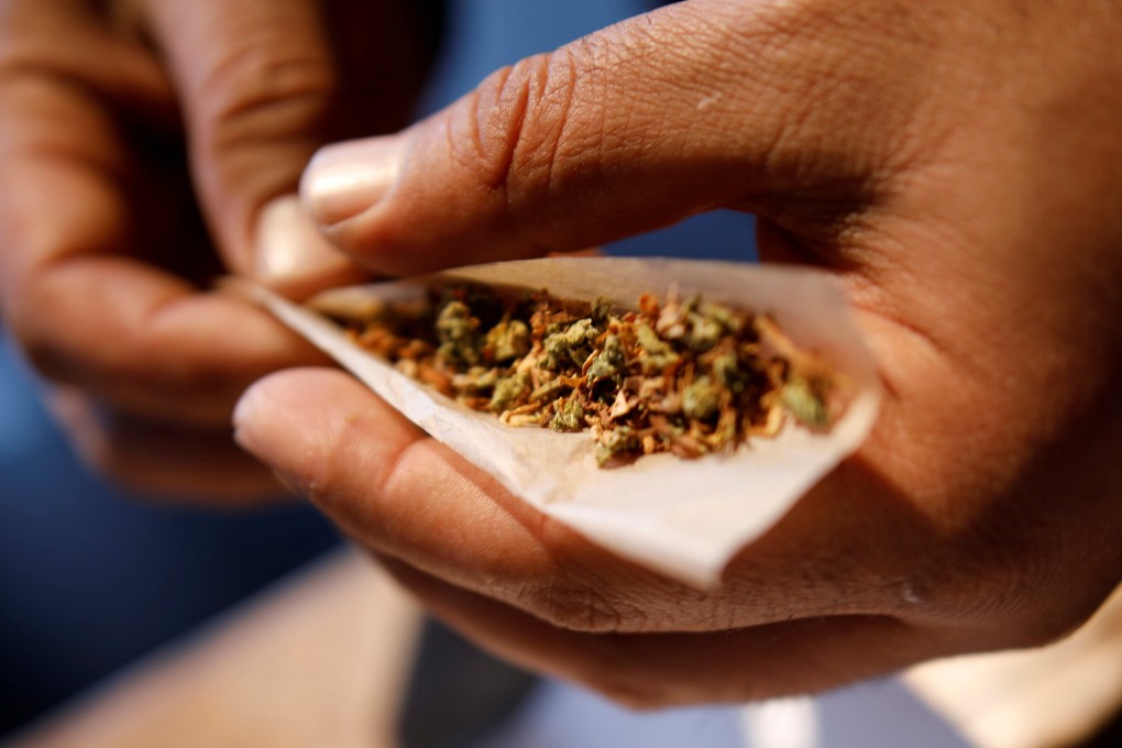 A man prepares a mix of tobacco and marijuana for smoking. Photo: Reuters