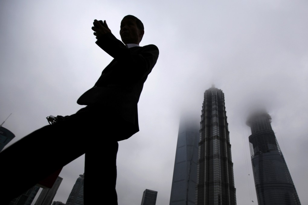 A businessman looks at his smartphone as he walks in the financial area of Pudong in Shanghai. As part of a broader crackdown on shadow banking, Chinese leaders are shrinking the peer-to-peer online lending market that spawned the nation’s biggest Ponzi scheme, protests in major cities and life-altering losses for thousands of savers. Photo: Reuters