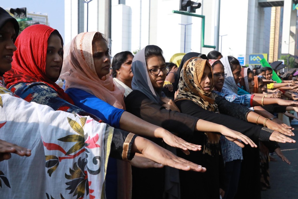 Women hold out their hands as they take part in the protest in Kerala. Photo: AFP