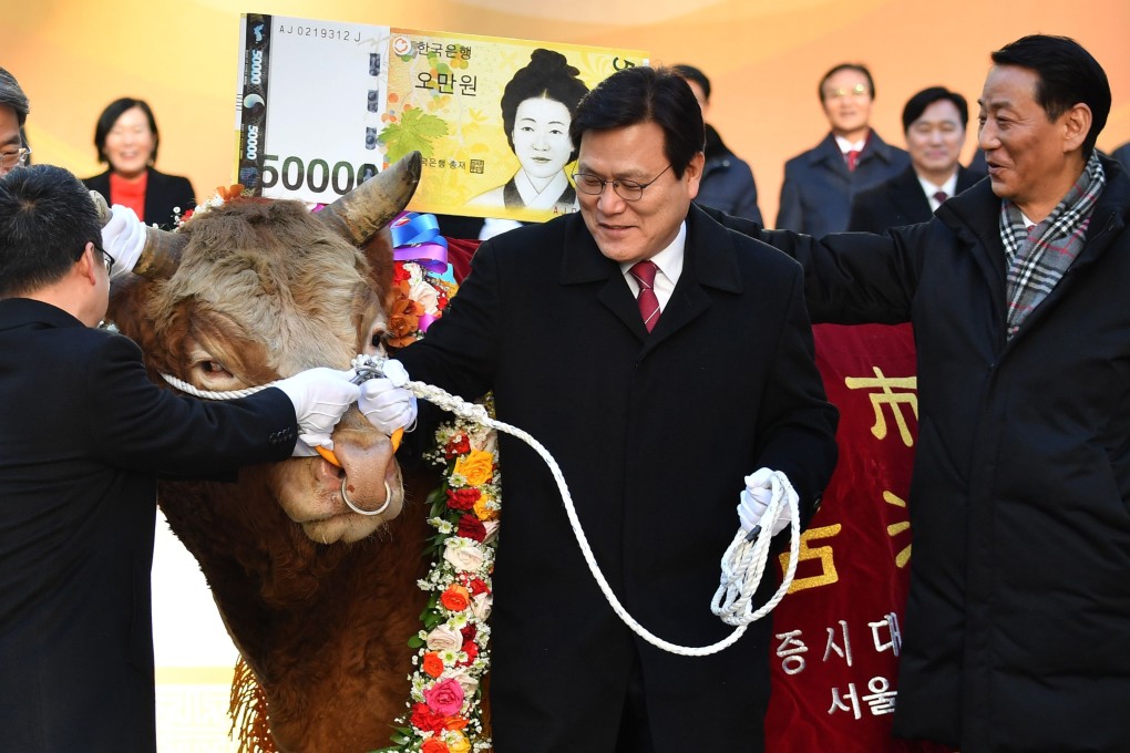 South Korea's Financial Services Commission chairman Choi Jong-ku is handed the reins to a bull during a ceremony celebrating the first trading session of 2019 at the Korea Exchange in Seoul. Photo: AFP