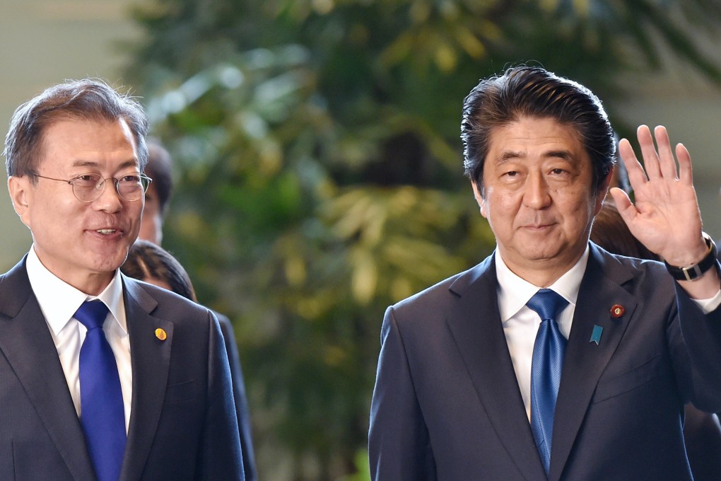 South Korean President Moon Jae-in (L) with Japanese Prime Minister Shinzo Abe. Photo: Bloomberg