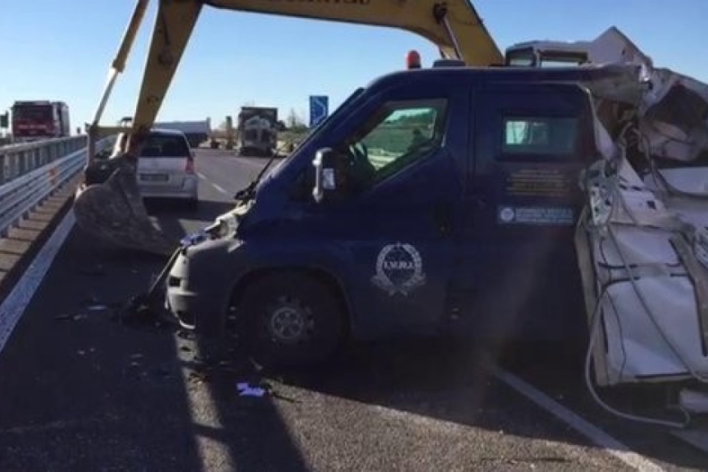 An armoured car is seen with the mechanical digger that was used to rip it apart, on the highway between Bari and Matera in Italy. Photo: Sky News