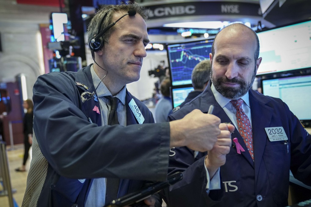 Traders bump fists on the floor of the New York Stock Exchange ahead of the opening bell on Friday. Photo: AFP