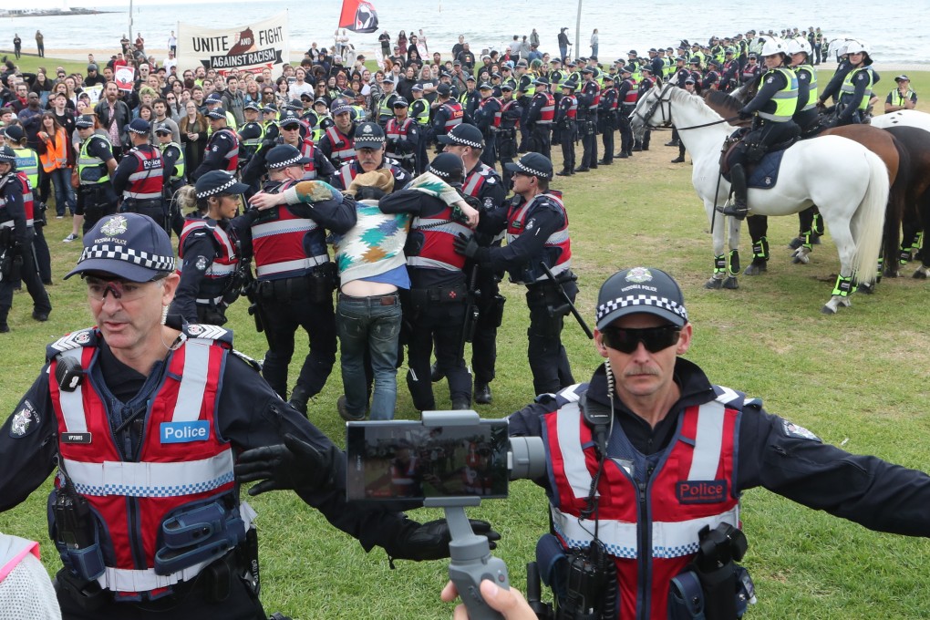 Police keep protesters apart as a man is arrested on St Kilda foreshore in Melbourne on January 5, 2019. Photo: EPA