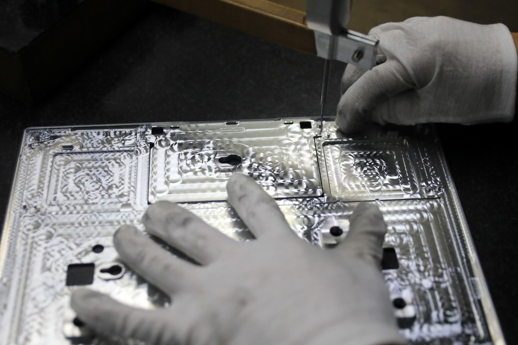 This photo taken on November 19, 2018 shows a worker checking laptop parts in a factory in the Hangyong Auto Industrial Park, in Lu'an City, in China's Anhui Province. – The factory produces equipment for Toshiba, Matsushita and other international brands. (Photo by STR / Agence France-Presse) / China OUT