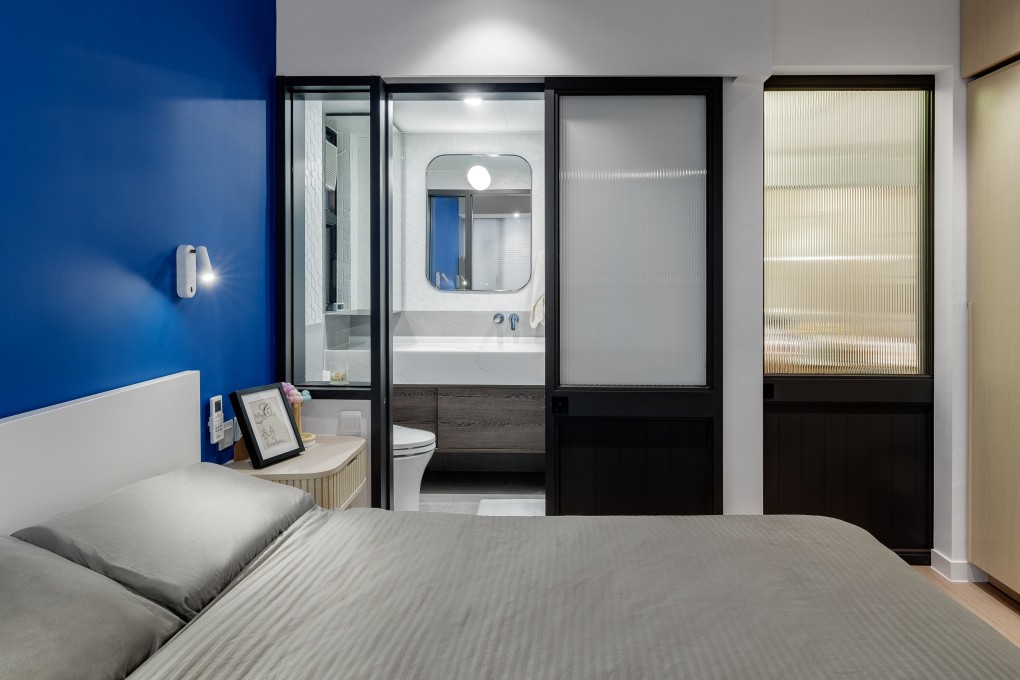 The master bedroom in Carmen and Callum Tse’s Tin Hau apartment boasts a bold, blue feature wall. Photography: Steven Ko