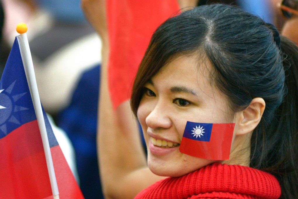 A supporter of mayoral candidate Ting Shou-chung from Taiwan’s main opposition Kuomintang party demonstrates with the national flag, in Taipei on November 24. Taiwan has a tradition of fiercely contested democratic elections. Photo: AFP