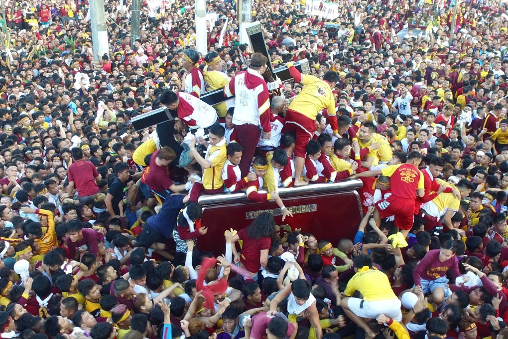 Catholic devotees jostle to reach the statue of the Black Nazarene during a procession to mark its feast day in Manila. Photo: EPA