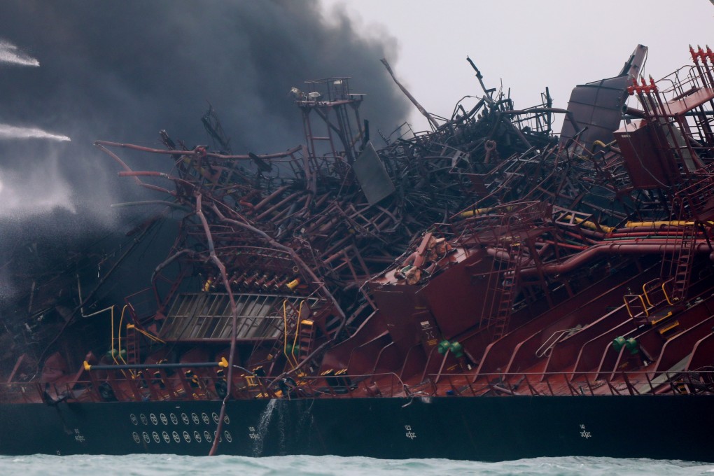 The oil tanker listing to one side as firefighters prepare to board. Photo: Sam Tsang