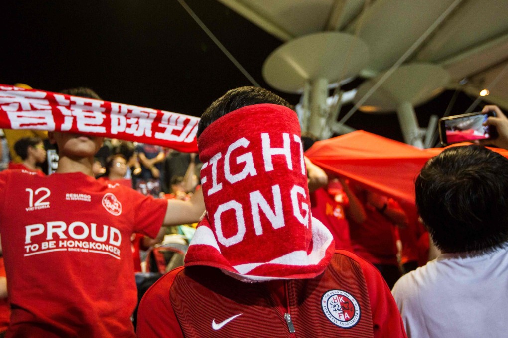 A Hong Kong fan covers his face during the Chinese national anthem before an international friendly soccer match between Hong Kong and Bahrain at Mong Kok Stadium. Photo: AFP