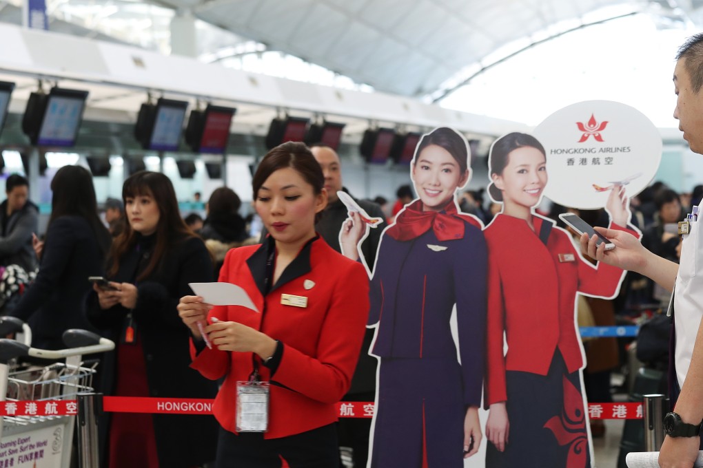 A Hong Kong Airlines employee waits for passengers near the airlines’ counter at Hong Kong International Airport. Photo: K.Y. Cheng