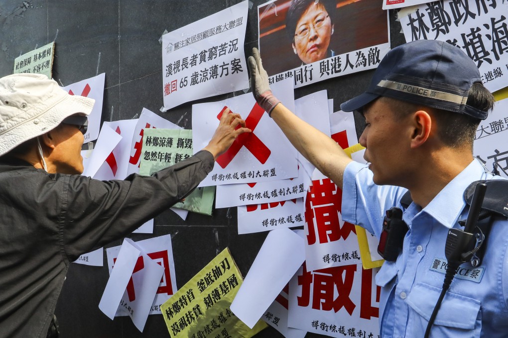 Protesters put up posters call on the government not to tighten the eligibility of CSSA payments outside government offices. Photo: Edmond So