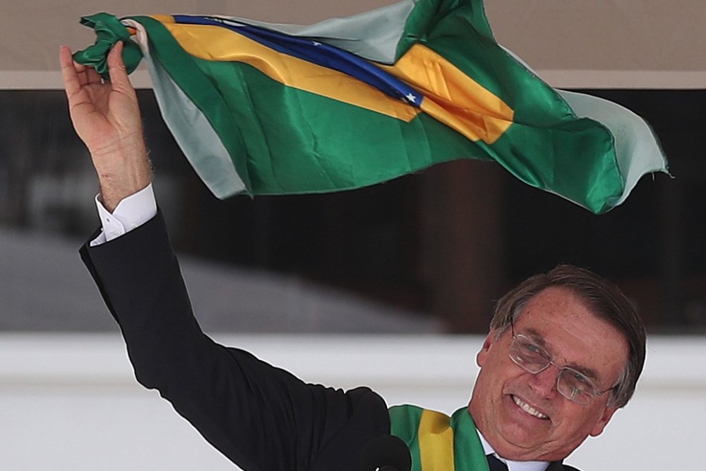 Jair Bolsonaro, Brazil’s new president, waves the national flag as he delivers a speech during his inauguration ceremony in Brasilia on Tuesday. Photo: EPA-EFE