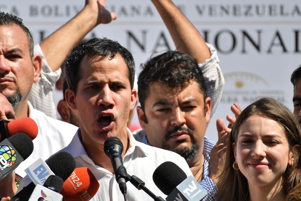 Venezuela’s National Assembly president Juan Guaido, accompanied by his wife Fabiana Rosales gestures before a crowd of opposition supporters during an open meeting in Caraballeda, Vargas State, Venezuela, on January 13, 2019. Photo: AFP