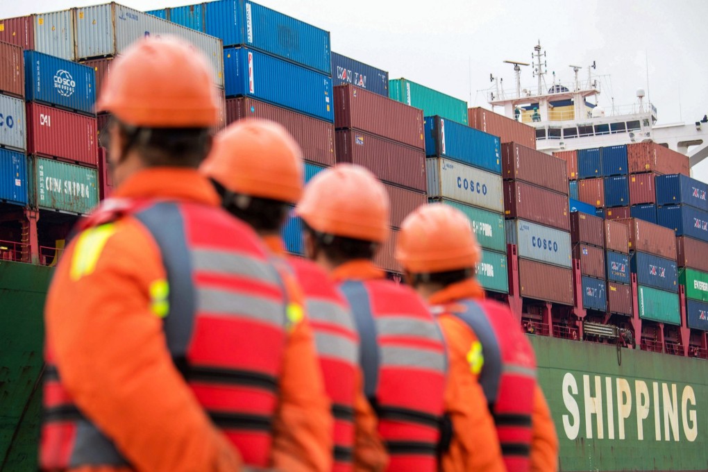 Employees look at a cargo ship at a port in Qingdao, east China's Shandong province on November 8, 2018. Photo: Agence France-Presse/China OUT