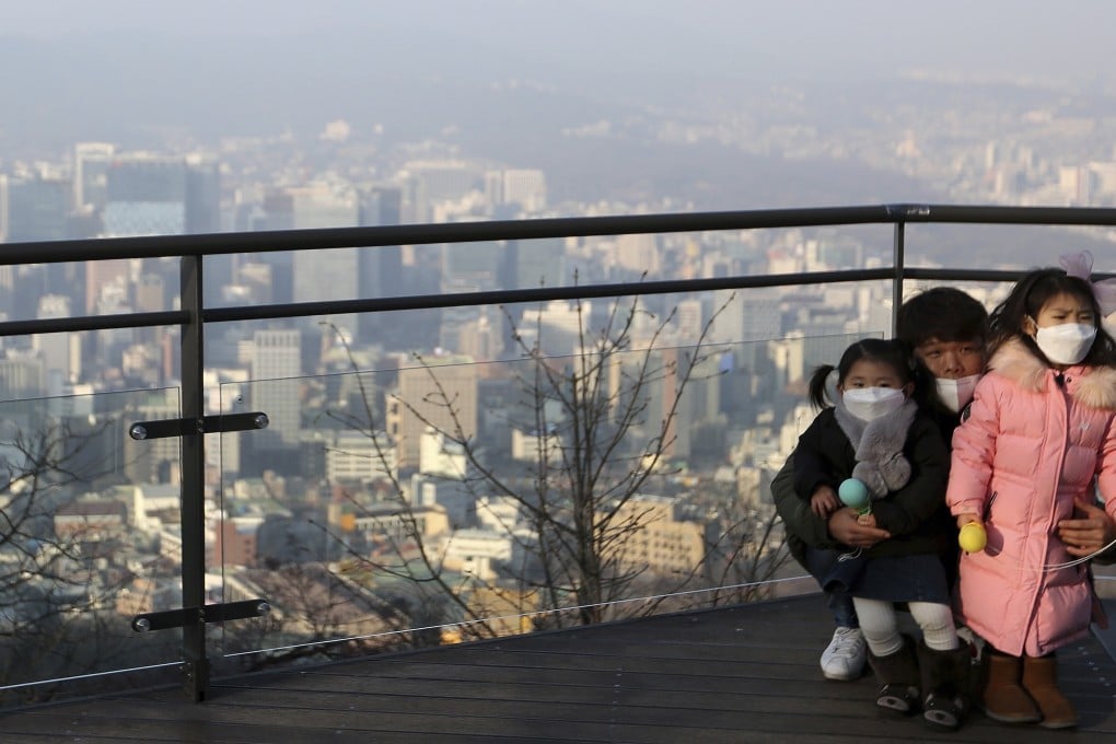 A family wears masks to protect themselves from a thick haze of fine dust in Seoul. Photo: AP