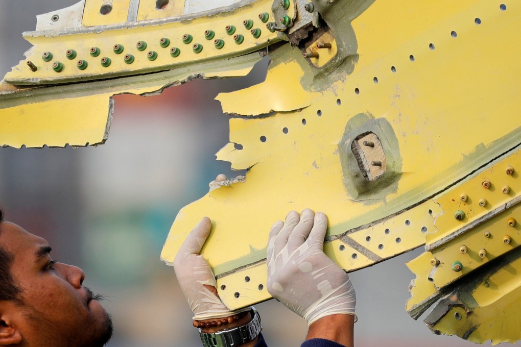 An Indonesian official carries debris from the crashed Lion Air flight JT610. Photo: Reuters