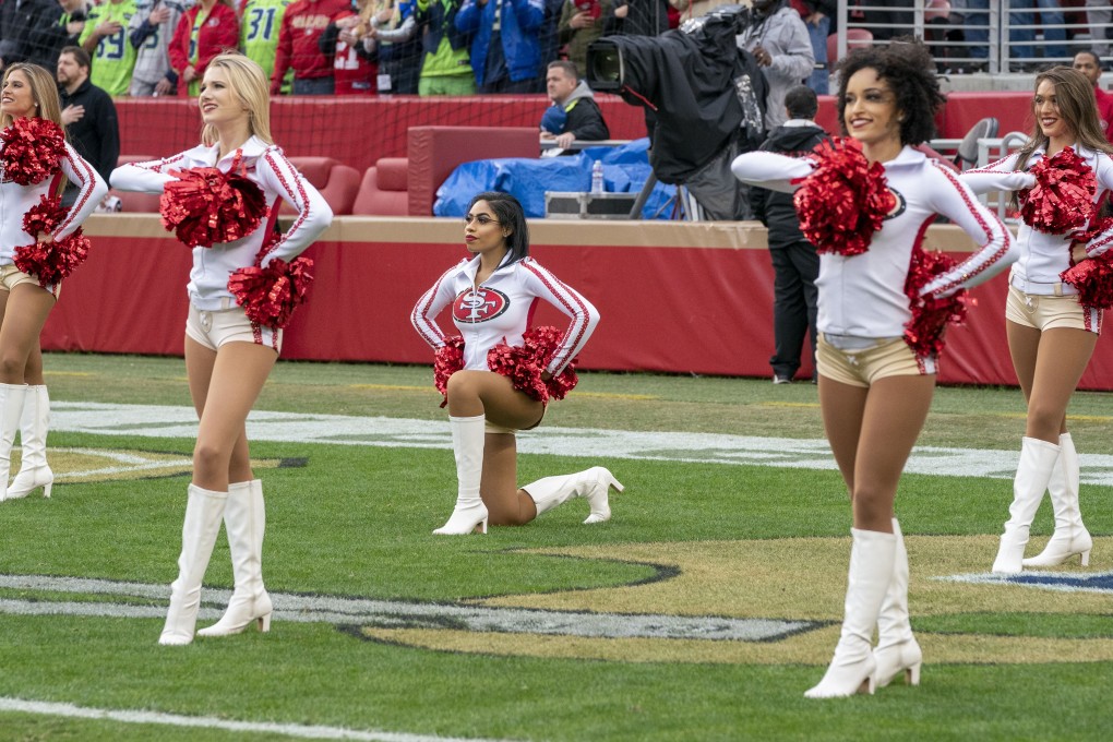 San Francisco 49ers cheerleader Kayla Morris kneels during the playing of the national anthem, before the NFL game against Seattle Seahawks in Santa Clara, California, on December 16. According to the United States Code, any person present during the playing or singing of the anthem ‘should’ stand at attention with their right hand over their heart, but there are no penalties for non-compliance. Photo: USA Today Sports