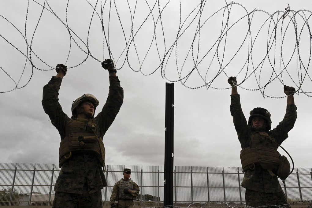 Members of the United States military place concertina wire along the border fence near Tijuana, Mexico. Photo: The Washington Post