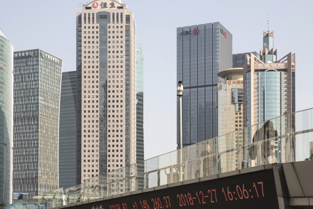 Pedestrians walk along an elevated walkway as an electronic ticker displays stock figures in Pudong's Lujiazui Financial District in Shanghai, China, on Friday, December 28, 2018. China announced plans to rein in the expansion of lending by the nation's regional banks to areas beyond their home bases, the latest step policy makers have taken to defend against financial risk in the world's second-biggest economy. Photo: Bloomberg