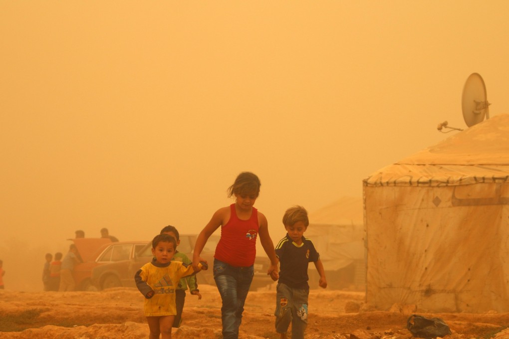 Syrian children walk in a sandstorm on September 7, 2015, at a refugee camp on the outskirts of Baalbek city in eastern Lebanon. As of 2017, more than 68 million people had been displaced globally, but Hong Kong continues to bury its head in the sand. Photo: AFP