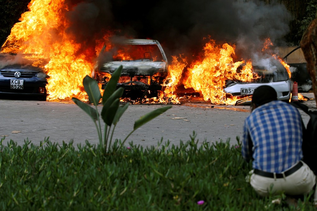 Cars are seen on fire at the scene of explosions and gunshots in Nairobi, Kenya on Tuesday. Photo: Reuters