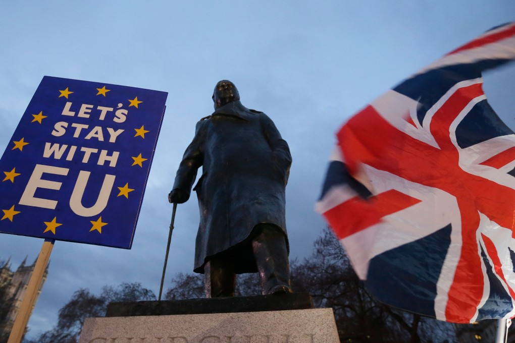 Pro-Brexit and anti-Brexit protesters wave a Union flag and a placard respectively, in front of the statue of Winston Churchill outside the Houses of Parliament in London on Tuesday. Photo: Xinhua