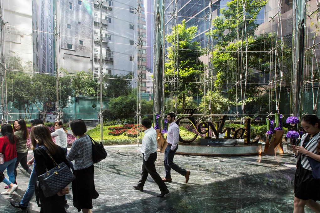 Office workers walking through the foyer of The Center office building in Hong Kong on October 27, 2017. Photo: Agence France-Presse
