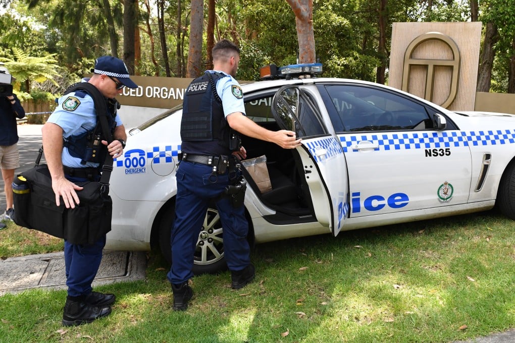 Police in Australia place evidence bags into a car at the scene of a double stabbing at the Church of Scientology headquarters in Chatswood, Sydney on January 3. Photo: EPA