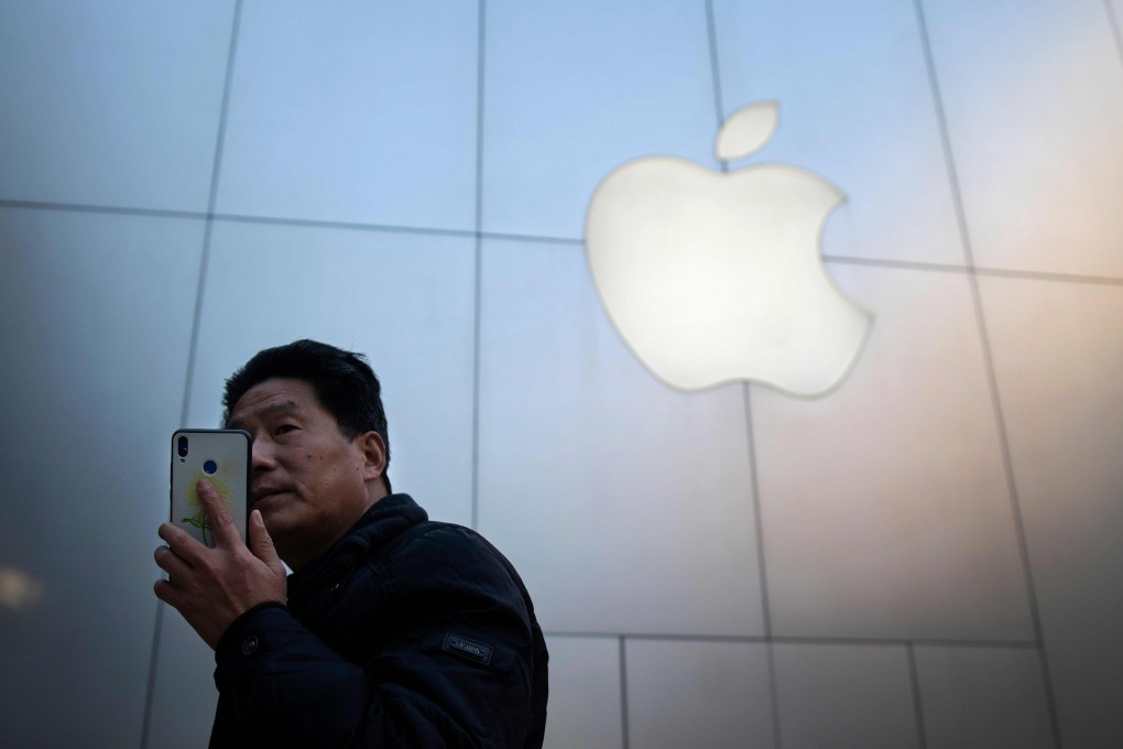 A man uses a smartphone outside an Apple store in Beijing on January 4, 2019. Apple cut its revenue outlook for the latest quarter on January 3, citing steeper-than-expected "economic deceleration" in China and emerging markets. Photo: AFP