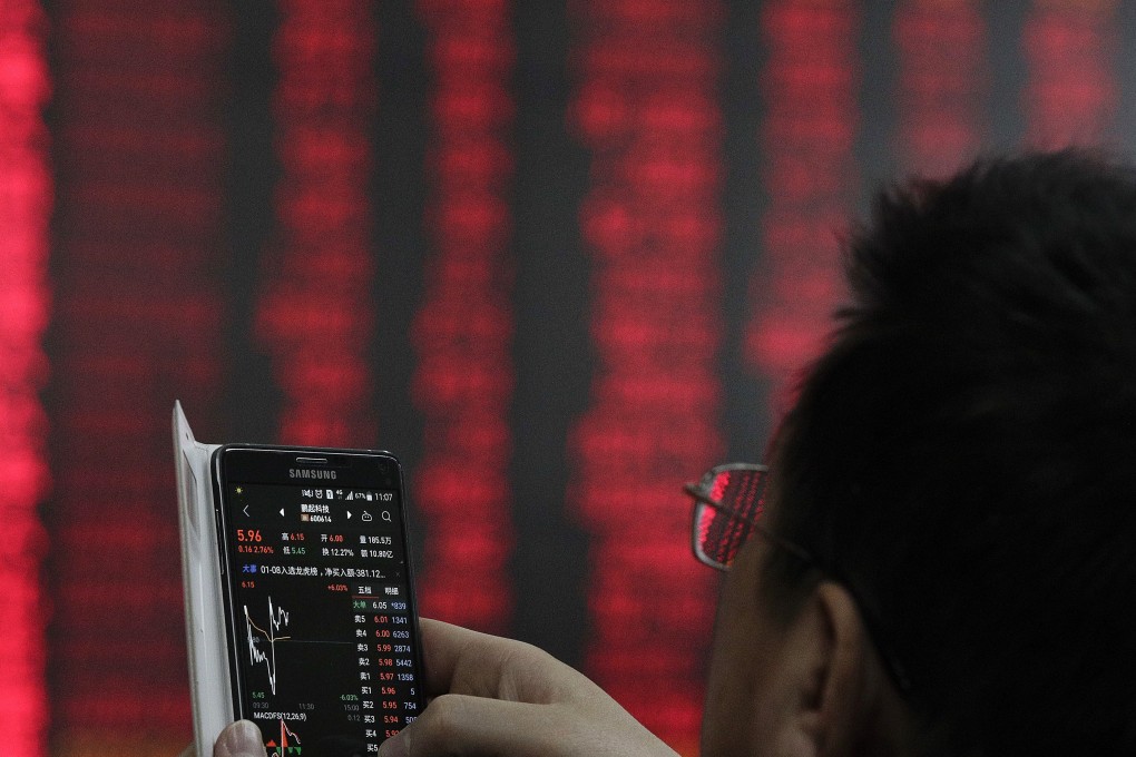 A man checks stock prices on his smartphone at a brokerage house in Beijing on January 9, 2019. Photo: Associated Press