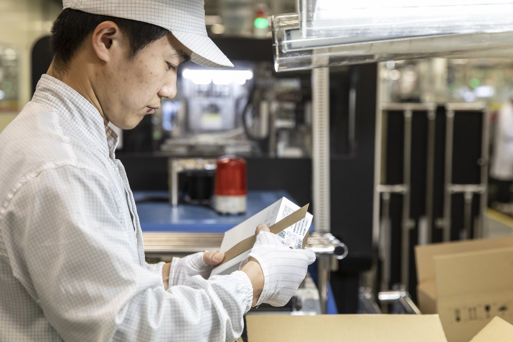 An employee inspects a box on the assembly line of a Huawei Technologies mobile phone plant in Dongguan, China, on Tuesday. Photo: Bloomberg