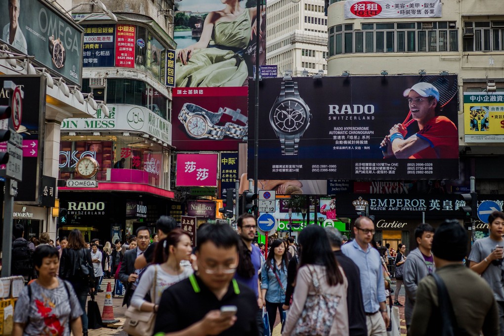People cross the street at a busy intersection in Causeway Bay in November 2012. Hong Kong’s emigration could rise dramatically if the government fails to address key livelihood and quality of life issues. Photo: AFP