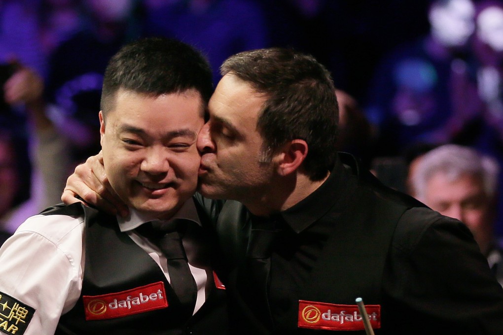 Ronnie O’Sullivan plants a kiss on Ding Junhui’s cheek after beating him in the Masters semi-finals in London. Photo: Xinhua