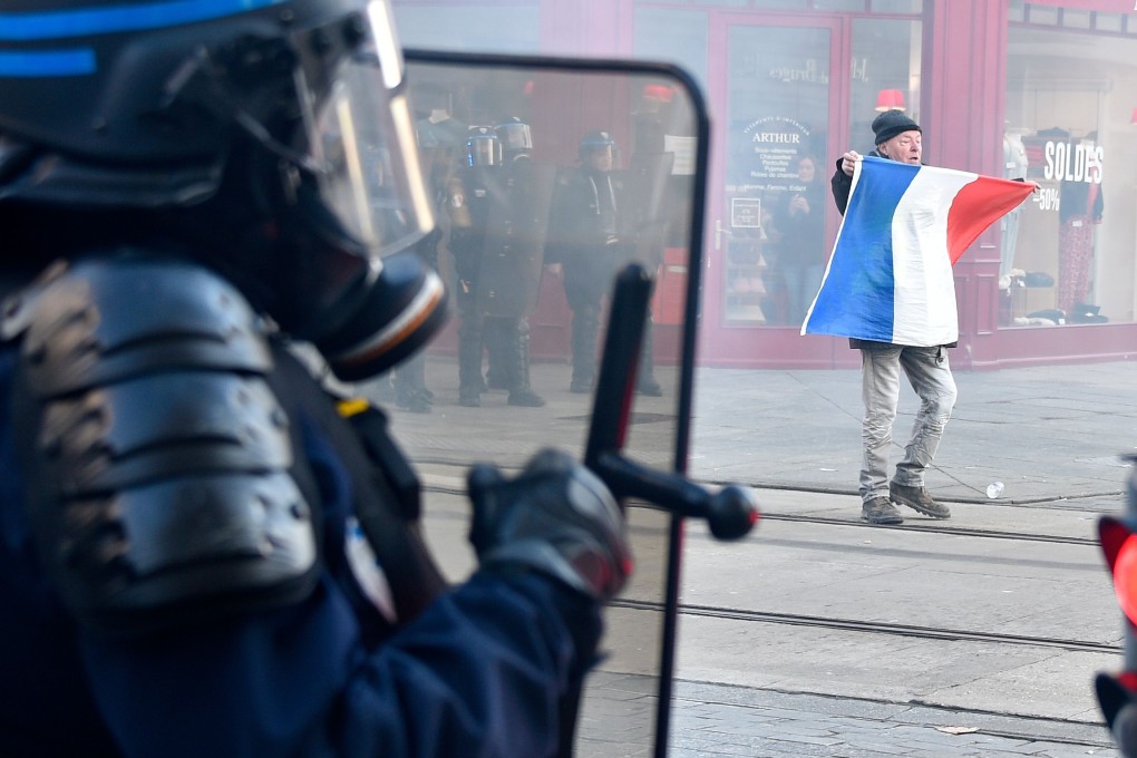 A protester with a French flag during an anti-government demonstration called by the yellow vest in Nancy, France on Saturday. Photo: AFP