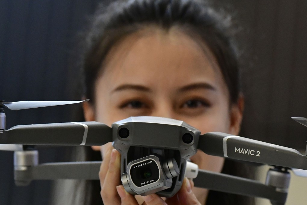 A hostess presents the Mavic 2 Pro drone at the booth of DJI during a trade show in Berlin on August 30, 2018. Photo: AFP