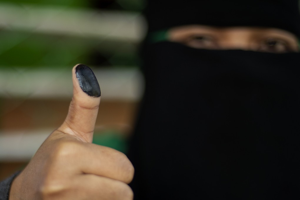A woman shows her inked thumb after voting in Cotabato City. Photo: AFP
