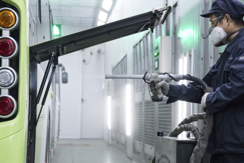 A worker uses dry ice to wash the buses at the Shanghai Bashi Public Transportation’s second division depot in Baoshan, in China. Picture: Zigor Aldama