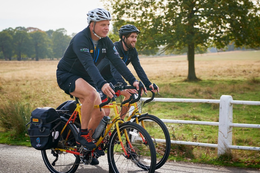 Ron Rutland (foreground) and James Owens are cycling from London to Tokyo to deliver the referee whistle for the opening game of the Rugby World Cup. Photos: DHL