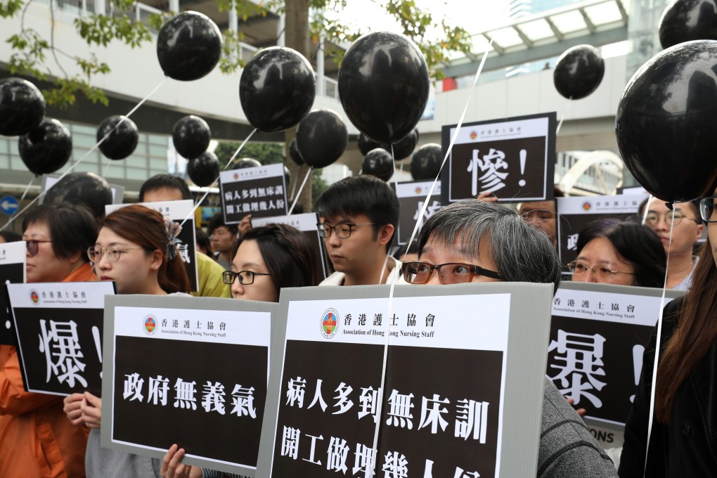 Protesters carry black balloons to symbolise their unhappiness and stress. Photo: Robert Ng