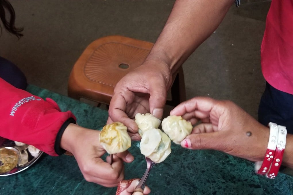 At the Cooking Momos with Home Chefs class in Kathmandu, the husband-and-wife instructors and two American students toast with their momo before tasting. Photo: Julie Lopez for The Washington Post