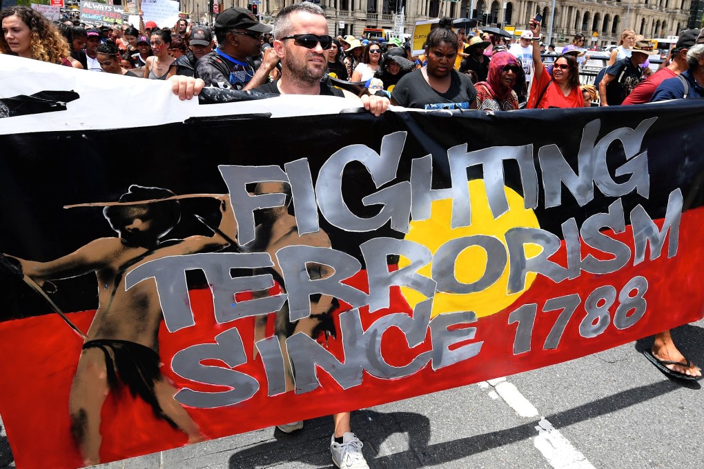 People hold signs and yell slogans as they join Aboriginal protesters in their march on Australia Day in central Brisbane on January 26, 2017. Photo: AAP