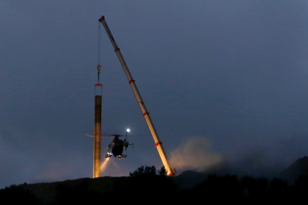 A Spanish Civil Guard helicopter lands near a crane in the area where a two-year-old boy fell into a deep well in Totalan. Photo: Reuters
