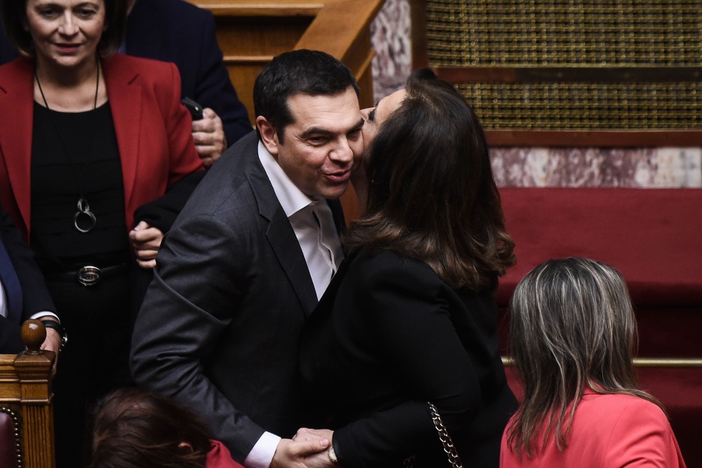 Greece's Prime Minister Alexis Tsipras (L) celebrates as he is congratulated following a voting session on the Prespa Agreement, an agreement aimed at ending a 27-year bilateral row by changing the name of Macedonia to the Republic of North Macedonia, at the Greek Parliament, in Athens, on January 25, 2019. Photo: AFP